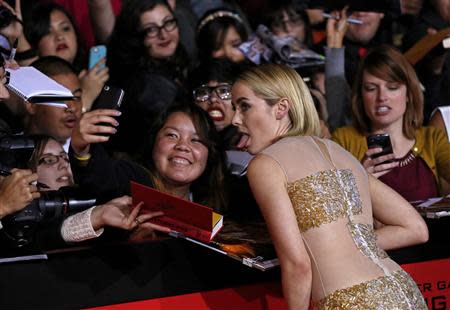Cast member Jena Malone poses with a fan at the premiere of "The Hunger Games: Catching Fire" in Los Angeles, California November 18, 2013. REUTERS/Mario Anzuoni