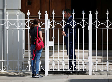 An unidentified woman talks with a man outside the gate at the entrance to the building of the Consulate General of Russia in San Francisco, California, U.S., August 31, 2017. REUTERS/Stephen Lam
