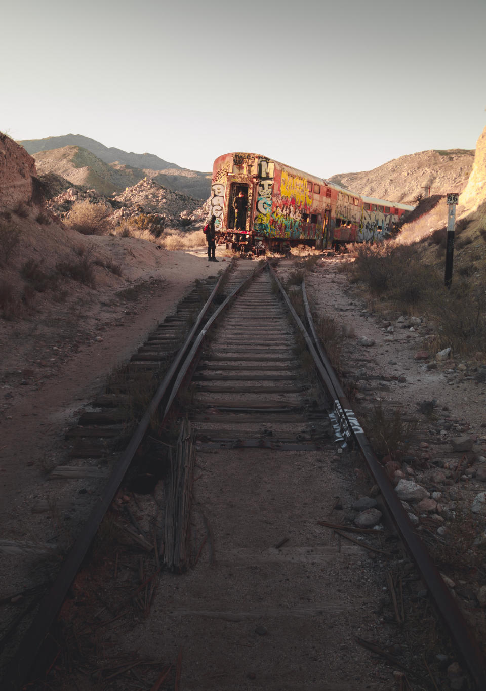 The train is covered in rust and graffiti and looks like it could tip over