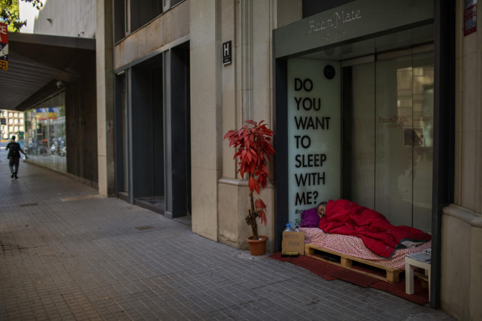 Reduan Elhammoudani, 45, from Syria, sleeps in a hotel entrance, closed during the coronavirus outbreak in Barcelona, Spain, Saturday, June 6, 2020. Reduan fled Syria seven years ago, after his wife and two children, 3 and 7, were killed in a bombing during the war. Since the confinement began due to the coronavirus outbreak, Reduan has subsisted thanks to the charity of the neighbourhood residents. (AP Photo/Emilio Morenatti)