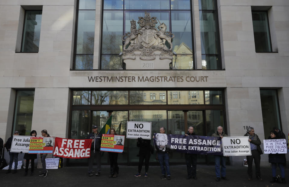 Protesters hold banners outside Westminster Magistrates Court in London, where Julian Assange is due to appear, Monday, Jan. 13, 2020. Protesters will be insisting that Assange should not be extradited to the US for his reporting of the Iraq and Afghanistan war. They insist he will not face a fair trial in the United States where the charges against him could result in imprisonment for 175 years. Assange will be transported from Belmarsh high-security prison. (AP Photo/Kirsty Wigglesworth)