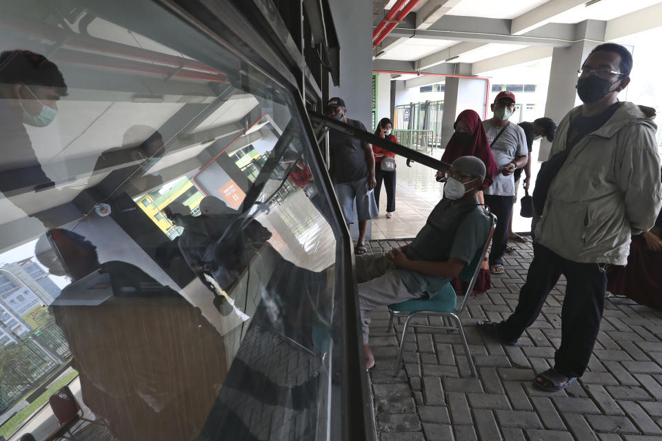 People register to receive a shot of COVID-19 vaccine during a vaccination campaign at the Patriot Candrabhaga Stadium in Bekasi on the outskirts of Jakarta, Indonesia Friday, Nov. 26, 2021. Indonesia has significantly recovered from a mid-year spike in coronavirus cases and deaths that was one of the worst in the region, but with its vaccination drive stalling and holidays approaching, experts and officials warn the island nation could be set soon for another surge. (AP Photo/Achmad Ibrahim)