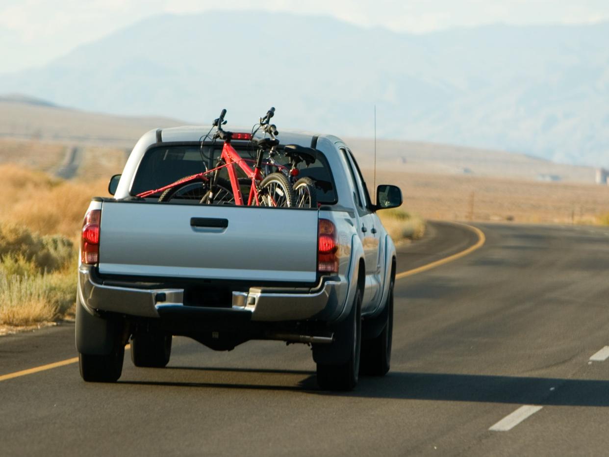 A pick up truck heads down the road on a mountain bike trip.