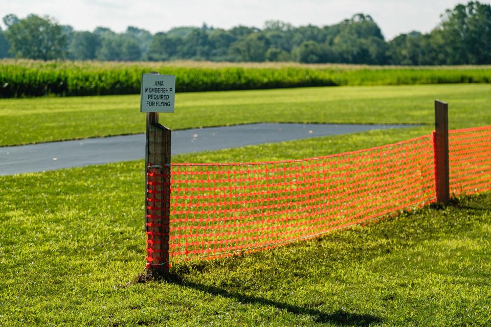 A sign in the field used by the Old Town Valley Flyer's Club informs pilots of the necessity of Academy of Model Aeronautics membership before taking flight, Saturday, Aug. 12 in Lawrence Township.