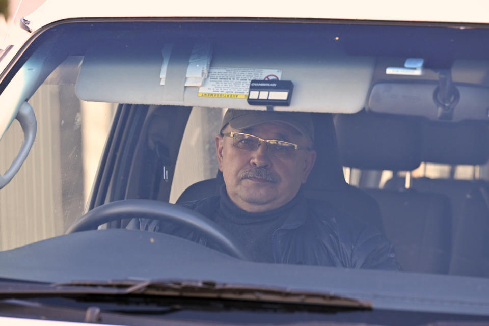 A man sits in a van with Russian diplomatic number plates outside the site of the former Russian embassy site in Canberra, Australia, Monday, June 26, 2023. Australia's highest court dismissed Russia's application for an injunction that would have prevented Moscow's embassy being evicted from a site in the national capital. A man who had been occupying the site in a portable cabin for more than a week in an apparent act of Russian defiance left soon after. (Mick Tsikas/AAP Image via AP)