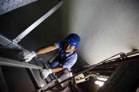 A worker inspects the interior of a wind turbine used to generate electricity, at a wind farm in Guazhou, 950km (590 miles) northwest of Lanzhou, Gansu Province September 15, 2013. REUTERS/Carlos Barria