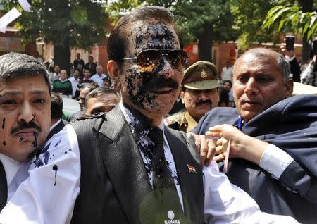 The Sahara group chairman Subrata Roy (C) with his face smeared in ink thrown by an unidentified man upon his arrival at the Supreme Court in New Delhi March 4, 2014. REUTERS/Stringer