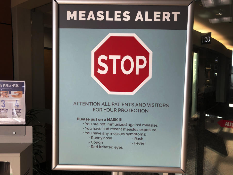 FILE - In this Jan. 30, 2019 file photo signs posted at The Vancouver Clinic in Vancouver, Wash., warn patients and visitors of a measles outbreak. Washington state lawmakers voted Tuesday, April 23, 2019, to remove parents' ability to claim a personal or philosophical exemption from vaccinating their children for measles, although medical and religious exemptions will remain. (AP Photo/Gillian Flaccus, File)
