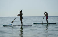 <p>Two paddle boarders take to the sea off of Boscombe beach in Dorset. (PA)</p> 