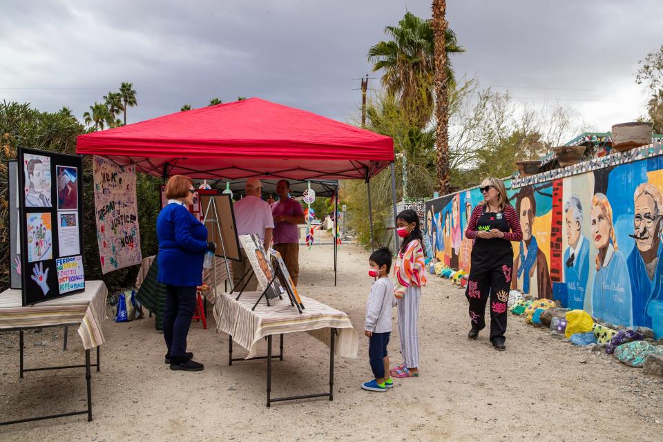 People look at artwork during the S.C.R.A.P. Gallery MLK Peace & Art Walk on Chuperosa Lane in Cathedral City on Saturday.