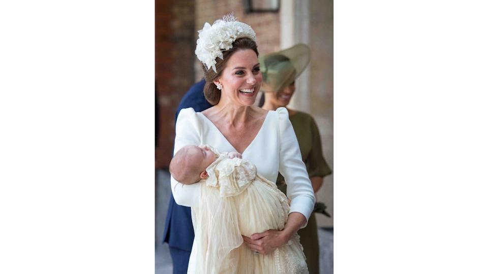 Britain's Catherine, Duchess of Cambridge holds Britain's Prince Louis of Cambridge on their arrival for his christening service wearing Alexander McQueen dress