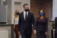 Gov. Gavin Newsom, middle, walks with Oakland Mayor Libby Schaaf at a news conference in Oakland, Calif., Monday, July 26, 2021. California will require state employees and all health care workers to show proof of COVID-19 vaccination or get tested weekly. Officials are tightening restrictions in an effort to slow rising coronavirus infections in the nation's most populous state, mostly among the unvaccinated. (AP Photo/Jeff Chiu)