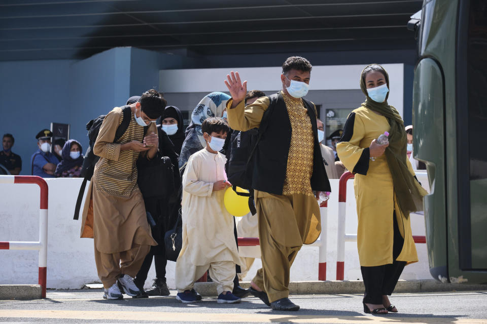 People evacuated from Afghanistan board a bus after arriving at the Rome Leonardo da Vinci airport, Saturday, Aug. 28, 2021. Italy’s final evacuation flight of refugees from Afghanistan has landed ain Rome. The Italian Air Force C-130J with 58 Afghan citizens aboard arrived on Saturday morning some 17 hours after it departed from Kabul airport and after a programmed stopover. (Mauro Scrobogna/LaPresse via AP)