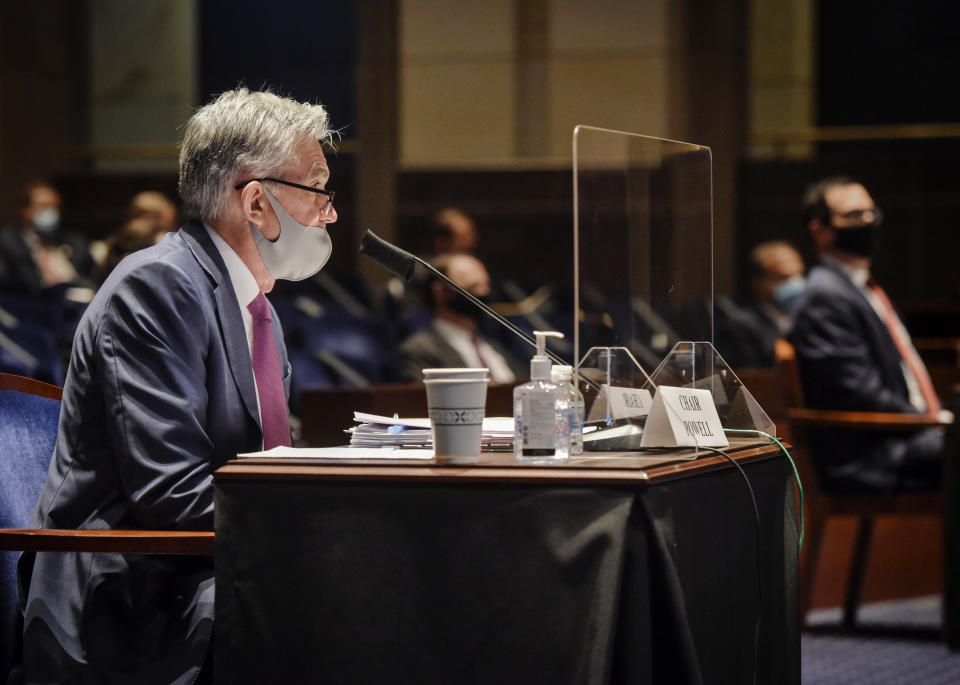 Federal Reserve Board Chairman Jerome Powell, left, and Treasury Secretary Stephen Mnuchin, far right, appear before a House Committee on Financial Services hearing on oversight of the Treasury Department and Federal Reserve pandemic response, Tuesday, June 30, 2020 on Capitol Hill in Washington. Powell sits behind protective shield. (Bill O'Leary/The Washington Post via AP, Pool)