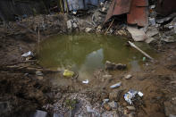 A crater in the courtyard of kindergarten in the aftermath of Russian missile strikes fired toward Kyiv early Sunday, Ukraine, Monday, June 27, 2022. (AP Photo/Nariman El-Mofty)