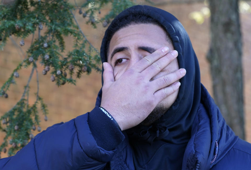 University of Virginia defensive tackle Aaron Faumui wipes his face as he talks about his teammates who were killed in an overnight shooting on the grounds of the University of Virginia Monday, Nov. 14, 2022, in Charlottesville, Va. Authorities say three people have been killed and two others were wounded in a shooting at the University of Virginia and a student suspect is in custody. (AP Photo/Steve Helber)