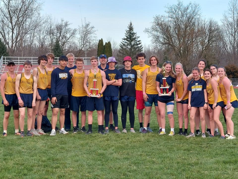 The Hillsdale Hornets boys and girls track and field teams with their Whitmore Lake Invitational trophies. The team is led by head coach Clay Schiman