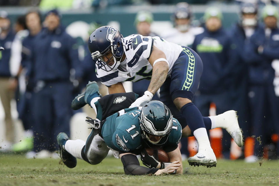 Philadelphia Eagles' Carson Wentz (11) is tackled by Seattle Seahawks' Mychal Kendricks (56) during the second half of an NFL football game, Sunday, Nov. 24, 2019, in Philadelphia. (AP Photo/Michael Perez)