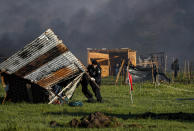 Police destroy shack homes as they carry out evictions at a squatters camp in Guernica, Buenos Aires province, Argentina, Thursday, Oct. 29, 2020. A court ordered the eviction of families who are squatting here since July, but the families say they have nowhere to go amid the COVID-19 pandemic. (AP Photo/Natacha Pisarenko)