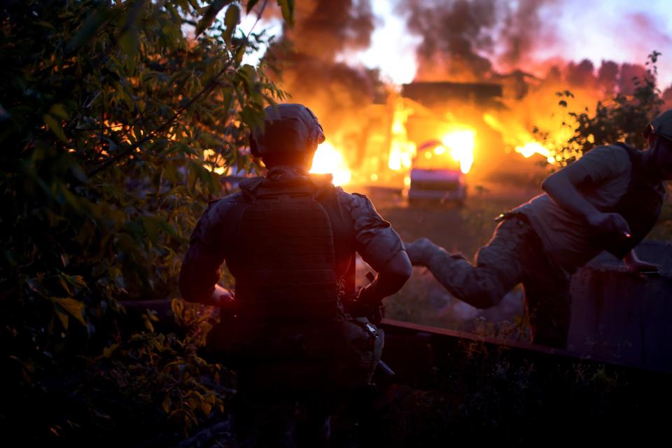 People take cover as a projectile whistles above after one already hit a structure (Getty Images)