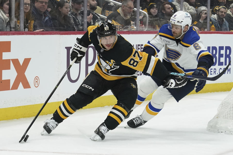 Pittsburgh Penguins' Sidney Crosby (87) tries to get past St. Louis Blues' Marco Scandella (6) during the second period of an NHL hockey game Saturday, Dec. 30, 2023, in Pittsburgh. (AP Photo/Matt Freed)