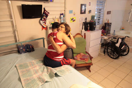 Ramona Febo-Boarman hugs her son Joey at their home in Bayamon, Puerto Rico, December 1, 2016. REUTERS/Alvin Baez