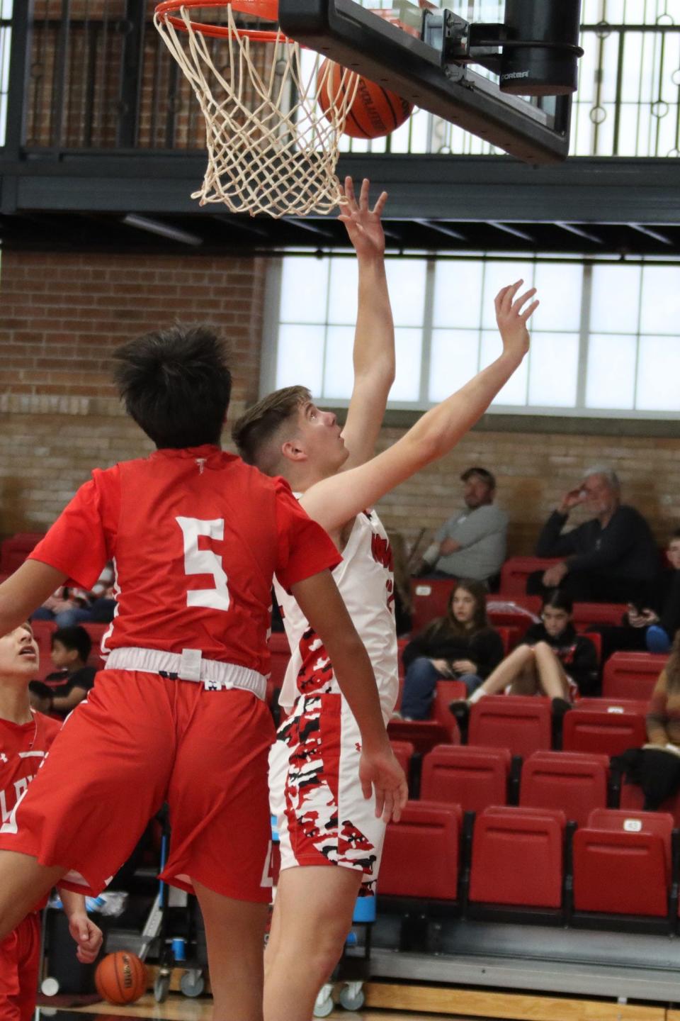 Loving's Kysiah Lujan attempts to stop a New Mexico Military Institute drive to the basket during a game early in the 2023 basketball season in Roswell.