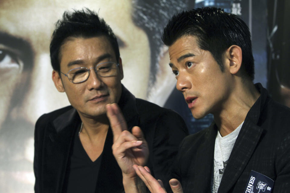 In this photo taken on Monday, Nov. 12, 2012, Hong Kong actor Aaron Kwok, right, speaks while Tony Leung Ka Fai listens during an interview for their new film "Cold War" in Taipei, Taiwan. (AP Photo/Chiang Ying-ying)