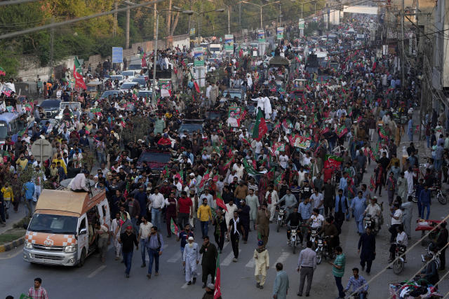 Supporters move with a convey of carrying Pakistan's former Prime Minister Imran Khan during an election campaign rally, in Lahore, Pakistan, Monday, March 13, 2023. Khan rallied thousands of supporters in eastern Pakistan on Monday as courts in the capital, Islamabad, issued two more arrest warrants for him over his failure to appear before judges in graft and terrorism cases, officials said. (AP Photo/K.M. Chaudary)