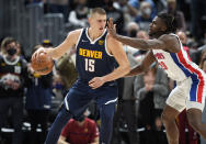 Denver Nuggets center Nikola Jokic, left, looks to drive to the rim as Detroit Pistons center Isaiah Stewart defends in the first half of an NBA basketball game, Sunday, Jan. 23, 2022, in Denver. (AP Photo/David Zalubowski)