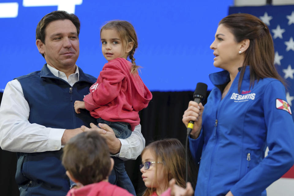 Republican presidential candidate Florida Gov. Ron DeSantis, left, carries daughter Mamie as wife Casey DeSantis, right, speaks during a campaign event at The Hangout on Saturday, Jan. 20, 2024, in Myrtle Beach, S.C. Standing in foreground are DeSantis' children Mason, left, and Madison. (AP Photo/Meg Kinnard)