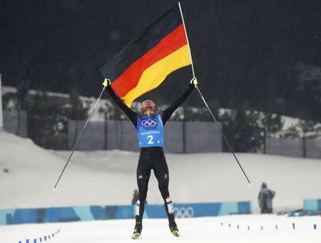 Nordic Combined Events - Pyeongchang 2018 Winter Olympics - Men's Team 4 x 5 km Final - Alpensia Cross-Country Skiing Centre - Pyeongchang, South Korea - February 22, 2018 - Johannes Rydzek of Germany celebrates with the German flag as he crosses the finish line. REUTERS/Kai Pfaffenbach