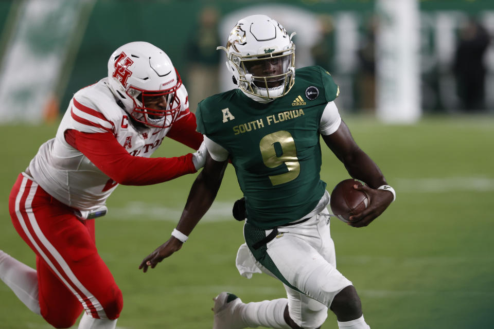 South Florida quarterback Timmy McClain scrambles while being pursued by Houston's Deontay Anderson during the first half of an NCAA college football game Saturday, Nov. 6, 2021, in Tampa, Fla. (AP Photo/Scott Audette)