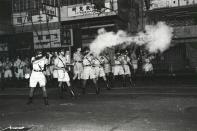 In this South China Morning Post (SCMP) archive photo taken on July 11, 1967, riot police shoot tear gas towards protesters, in North Point, Hong Kong