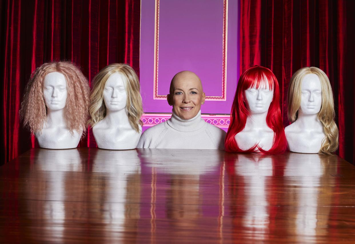 Pictured: Sarah Beeny in the middle with 4 heads stands with wigs on looking sideways at the heads - Sarah Beeny Vs Cancer (Channel 4)