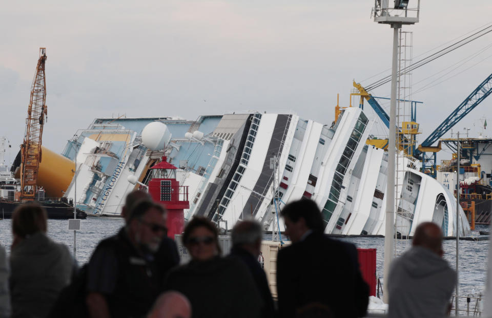 A view of the partially sunk Costa Concordia wreckage next to the Giglio Island, Italy, Sunday, Oct. 14, 2012. The first hearing of the trial for the Jan. 13, 2012 tragedy, where 32 people died after the luxury cruise Costa Concordia was forced to evacuate some 4,200 passengers after it hit a rock while passing too close to the Giglio Island, is taking place in Grosseto Monday Oct. 15, 2012. Captain Schettino, who was blamed for both the accident and for leaving the ship before the passengers, is scheduled to attend the hearing. (AP Photo/Gregorio Borgia)