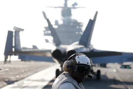 A U.S. Navy crew member looks at a F/A-18 Super Hornet fighter as it prepares for take off from the USS Ronald Reagan, a Nimitz-class nuclear-powered super carrier, during a joint naval drill between South Korea and the U.S., in the West Sea, South Korea, October 14, 2016. REUTERS/Kim Hong-Ji/Files