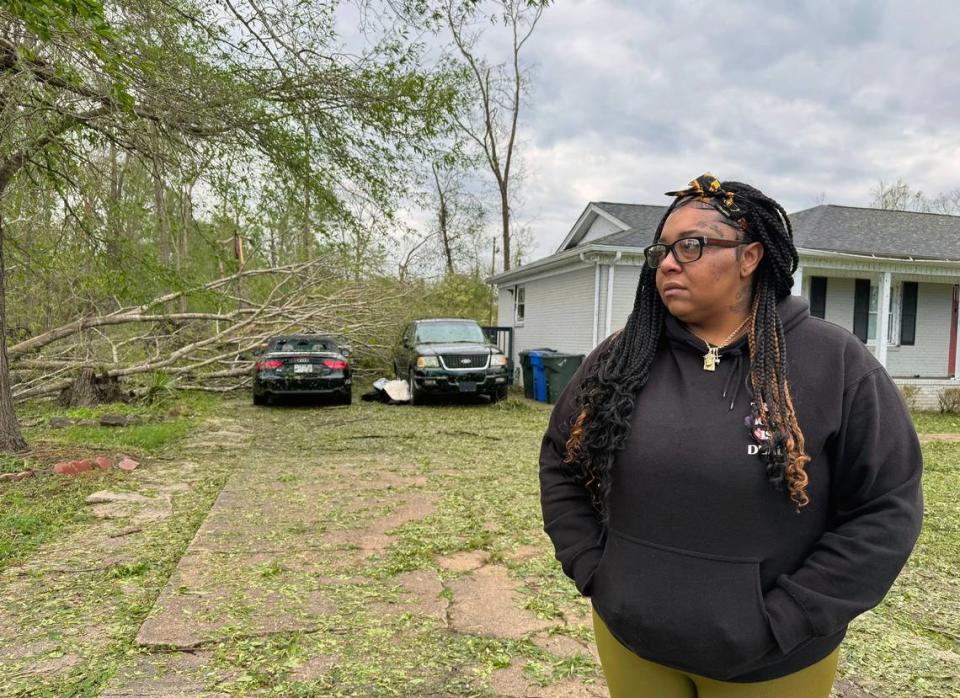 Rock Hill resident Harley Scott stands near damage sustained to several cars in her driveway from uprooted trees