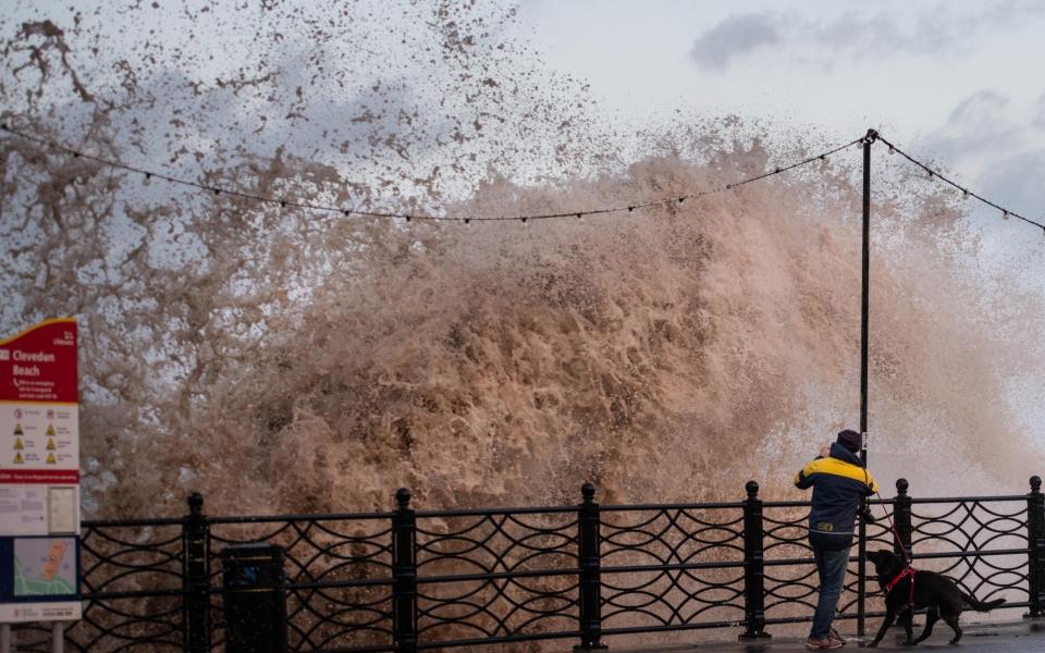 Dog walkers and amateur photographers get caught out by crashing waves hitting the Clevedon seawall in North Somerset - Lee Thomas