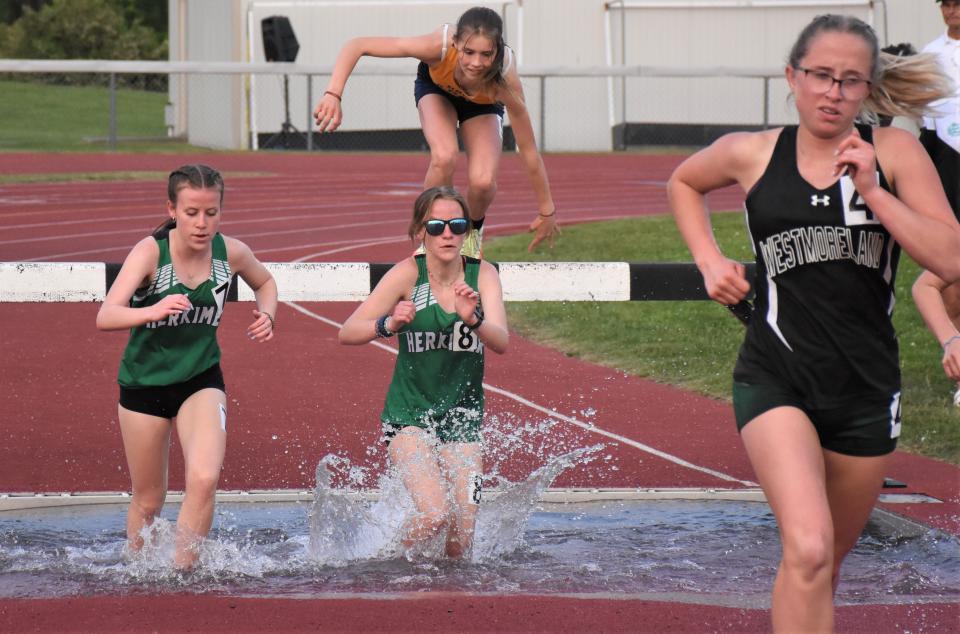 Herkimer sisters Abigail and Jillian Polus (from left) run through the water during the steeplechase Section III's Class C-1 track and field championship meet Tuesday in Little Falls.