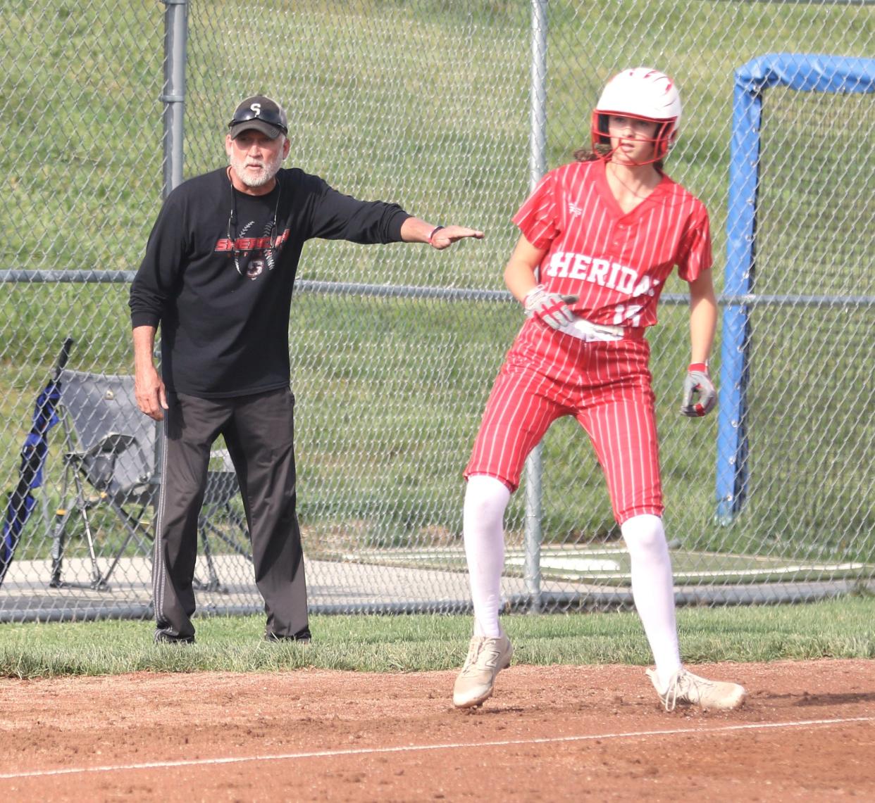 Sheridan's Hayley Clifton is held at third base by coach Mark Paxton after Avery Davis’ sacrifice bunt in the sixth inning of a 6-1 win over West Muskingum to complete a suspended game on Tuesday. The victory gave Paxton 400 for his career.