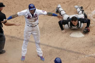 New York Mets' Javier Baez reacts after scoring the game winning run past Miami Marlins catcher Alex Jackson during the ninth inning of the first game of a baseball doubleheader that started April 11 and was suspended because of rain, Tuesday, Aug. 31, 2021, in New York. The Mets won 6-5. (AP Photo/Adam Hunger)