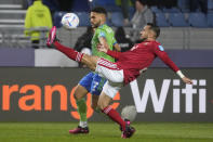 Al Ahly's Ali Maaloul, right, challenges for the ball with Cristian Roldan, of Seattle Sounders FC, during the FIFA Club World Cup soccer match between Seattle Sounders FC and Al Ahly FC at the Tangier stadium, in Tangier, Morocco, Saturday, Feb. 4, 2023. (AP Photo/Mosa'ab Elshamy)