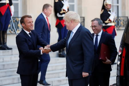 French President Emmanuel Macron accompanies British Prime Minister Boris Johnson after a meeting on Brexit at the Elysee Palace in Paris