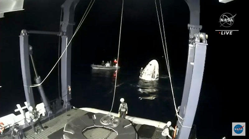 Recovery crews prepare to hoist the Crew Dragon aboard the 