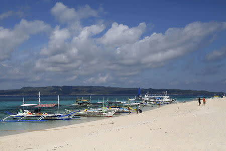 FILE PHOTO: Traditional boats line up the shore in a secluded beach on the island of Boracay, central Philippines January 18, 2016. REUTERS/Charlie Saceda/File Photo