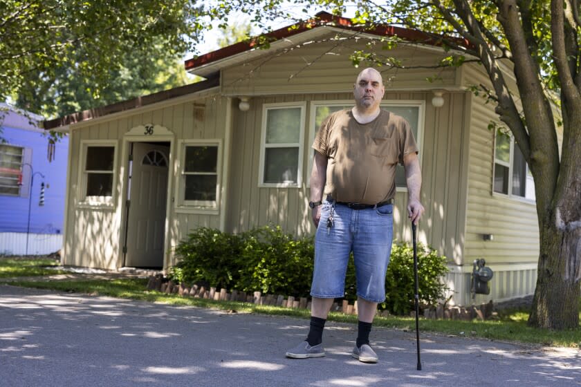 Jeremy Ward poses for a portrait in front of his home in the Ridgeview Homes mobile home community in Lockport, N.Y., June 23, 2022. Ward is one of the residents at Ridgeview participating in a rent strike after new owners of the park announced they were raising rents by six percent. "I moved here because it's basically the most affordable living," said Ward, who is disabled and living off of a fixed income. The plight of residents at Ridgeview is playing out nationwide as institutional investors, led by private equity firms and real estate trusts and sometimes funded by pension funds, swoop in to buy mobile home parks. (AP Photo/Lauren Petracca)