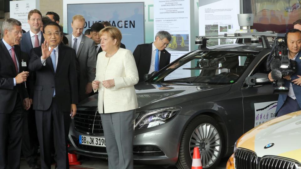 Li Keqiang, Ministerpräsident von China, und Bundeskanzlerin Angela Merkel informieren sich auf dem ehemaligen Flughafen Tempelhof bei einer Präsentation über das autonome Fahren.