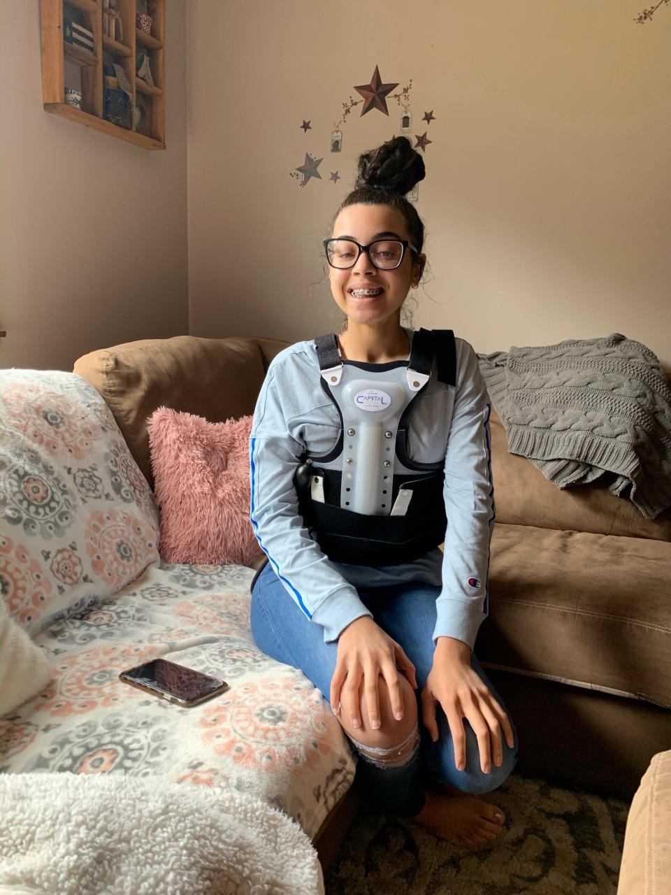 Olivia Badger recovering at home with a back brace.