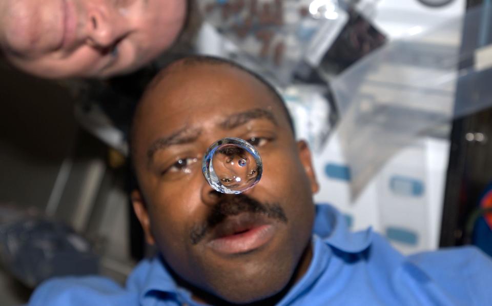 A water bubble floats in front of NASA's Leland Melvin aboard the space shuttle Atlantis